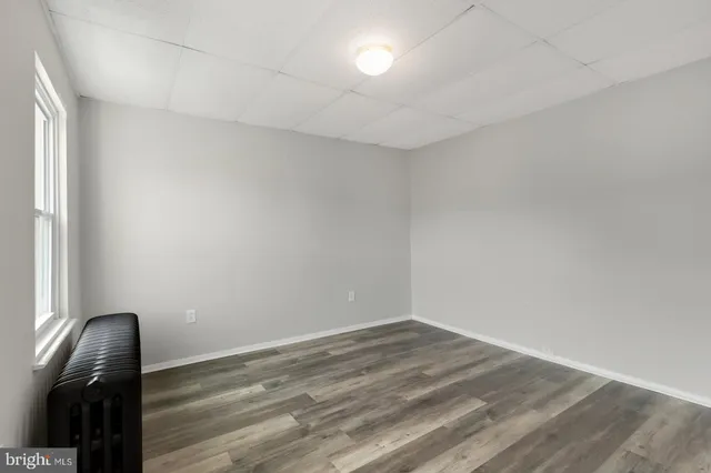a view of a livingroom with wooden floor and a window