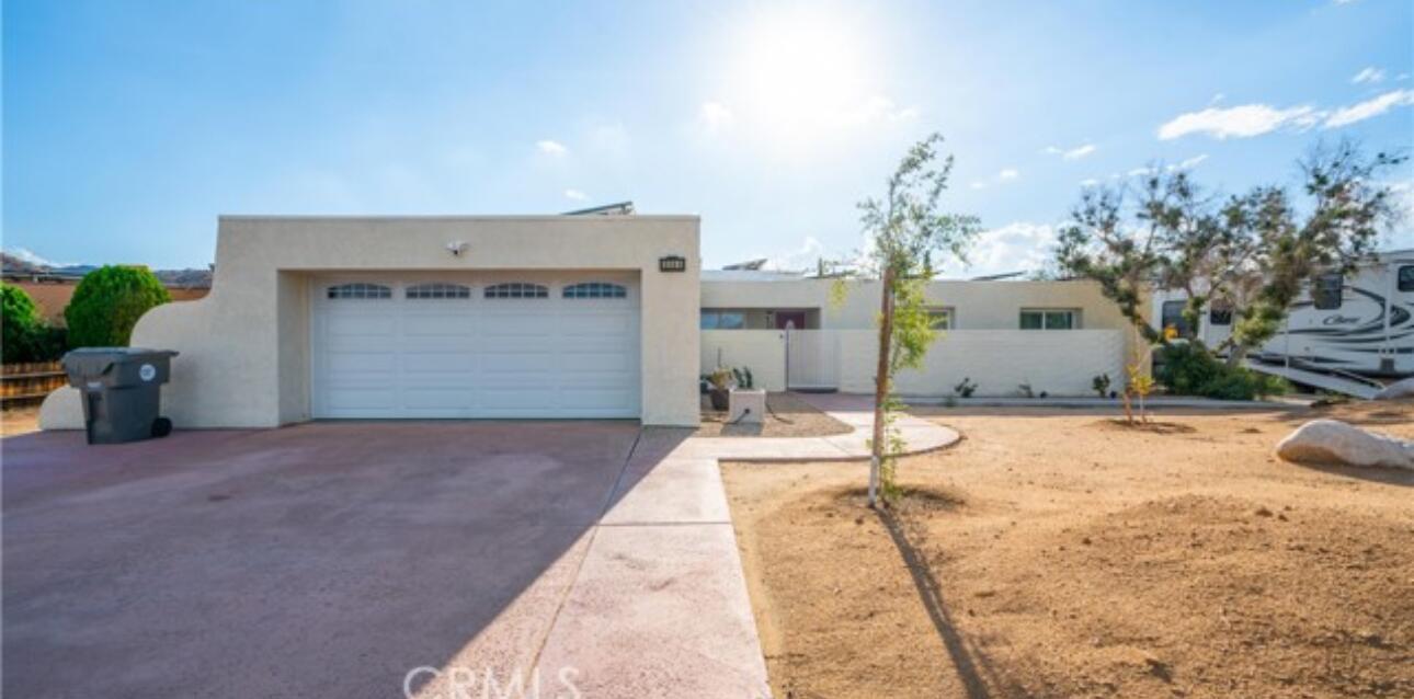 8564 Taft Court Yucca Valley, CA 92284 - Photo 3 of 25 a house with a yard and a garage