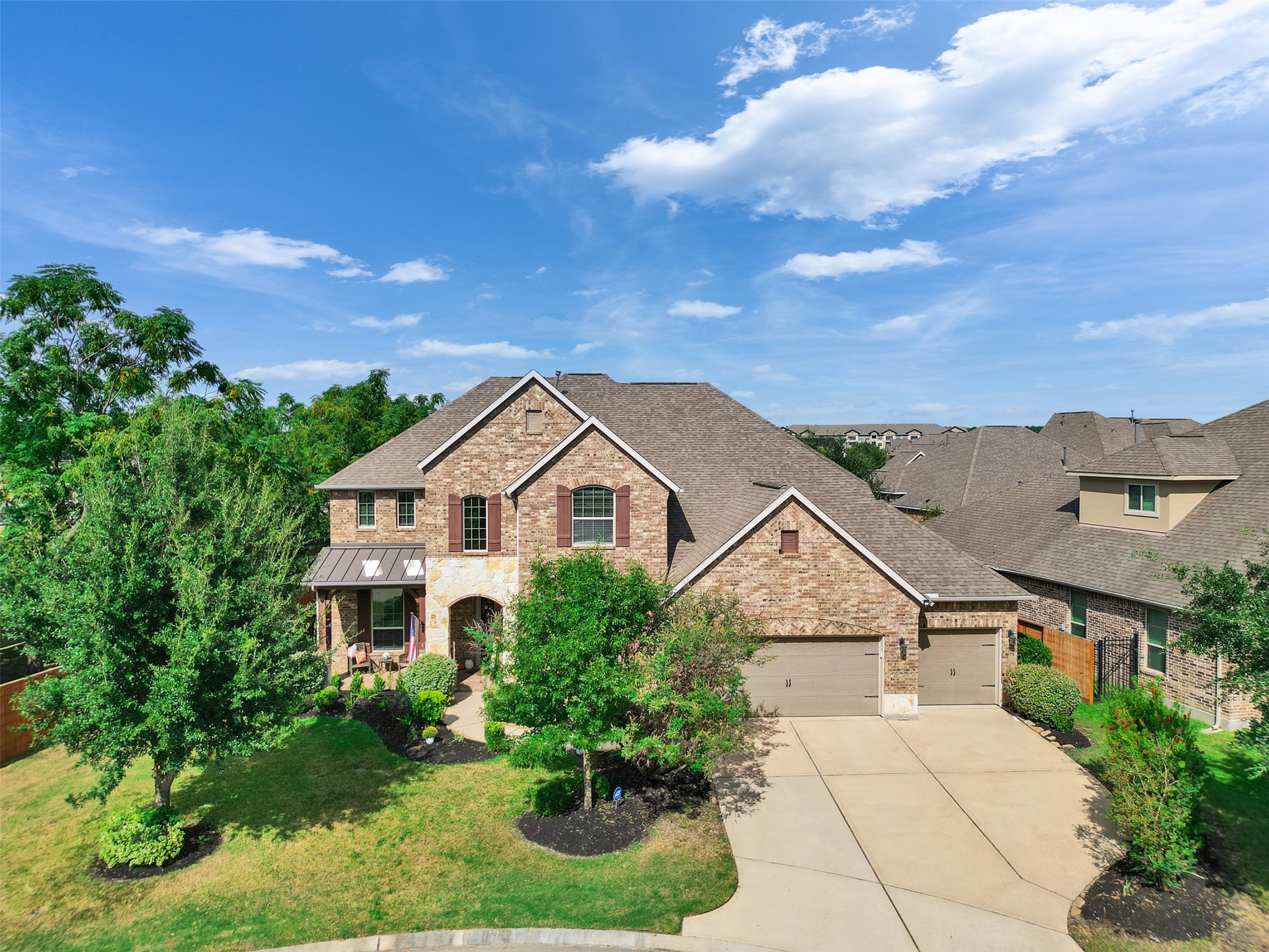 a view of a house with a big yard plants and large tree