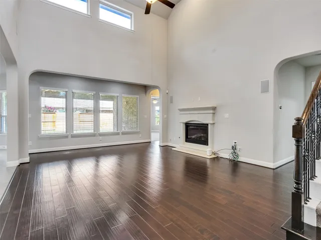 wooden floor fireplace and windows in an empty room
