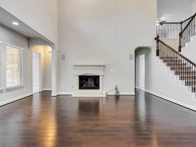 an empty room with wooden floor and fireplace