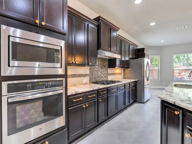 a kitchen with granite countertop stainless steel appliances and cabinets