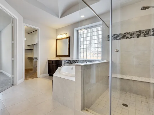 a spacious bathroom with a granite countertop sink a mirror and shower