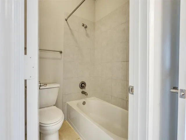 a white toilet sitting next to a bath tub