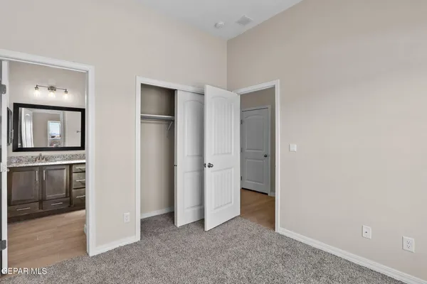 an empty room with closet and windows