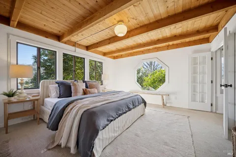 a white bed sitting in a bedroom next to a window