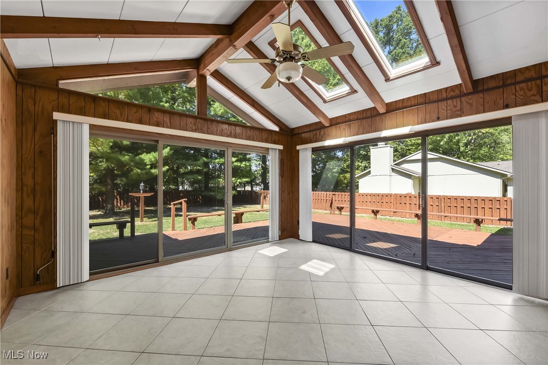 5076 North Barton Road North Ridgeville, OH 44039 - Photo 4 of 41 Unfurnished sunroom with a wealth of natural light, ceiling fan, and vaulted ceiling with skylight