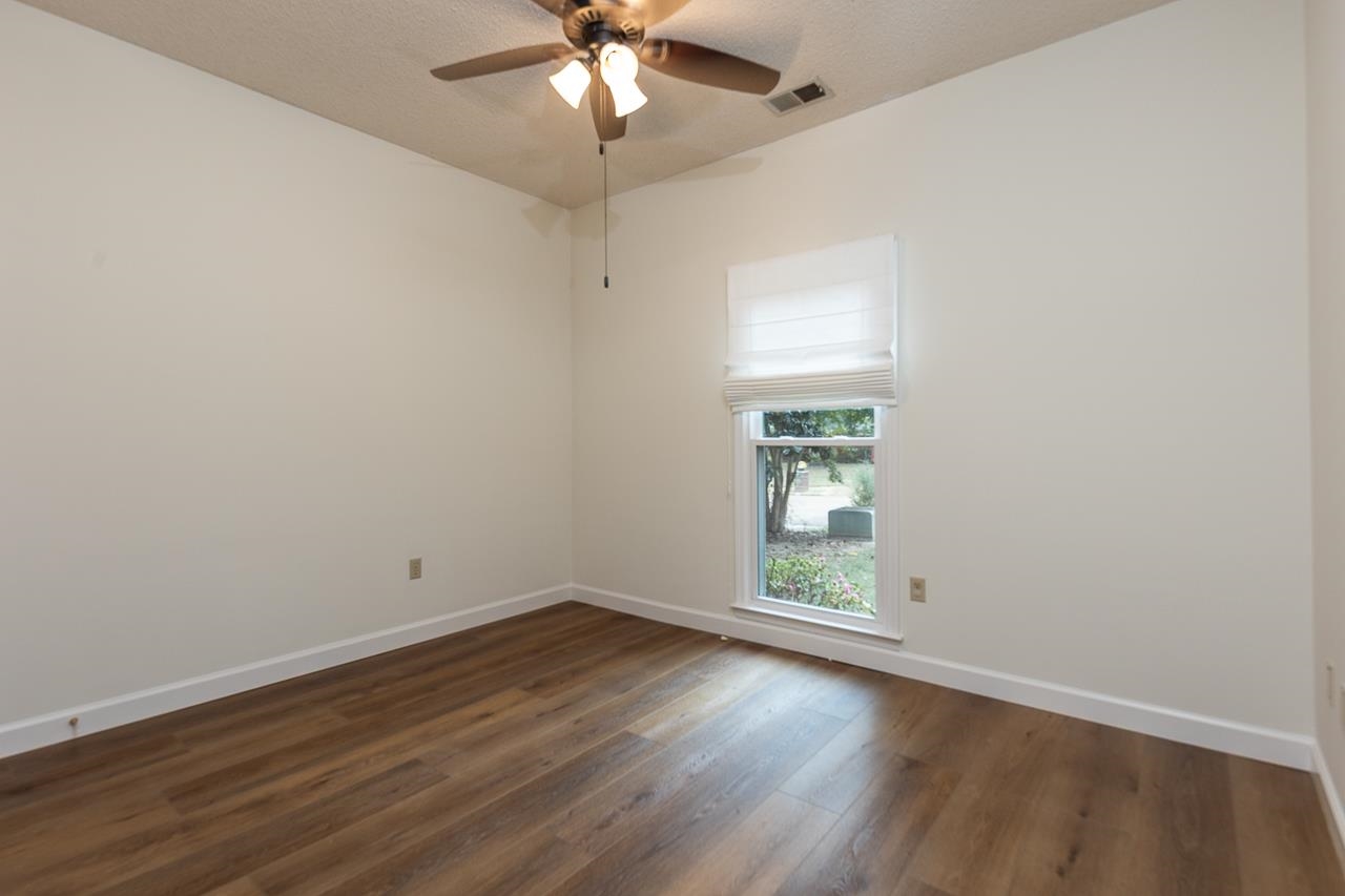 759 West Powell Road Collierville, TN 38017 - Photo 15 of 39 an empty room with wooden floor chandelier fan and windows