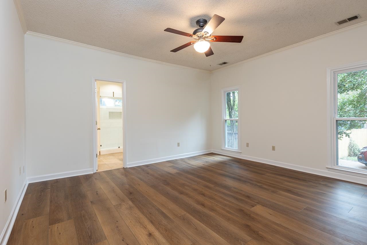 759 West Powell Road Collierville, TN 38017 - Photo 17 of 39 an empty room with wooden floor chandelier fan and windows