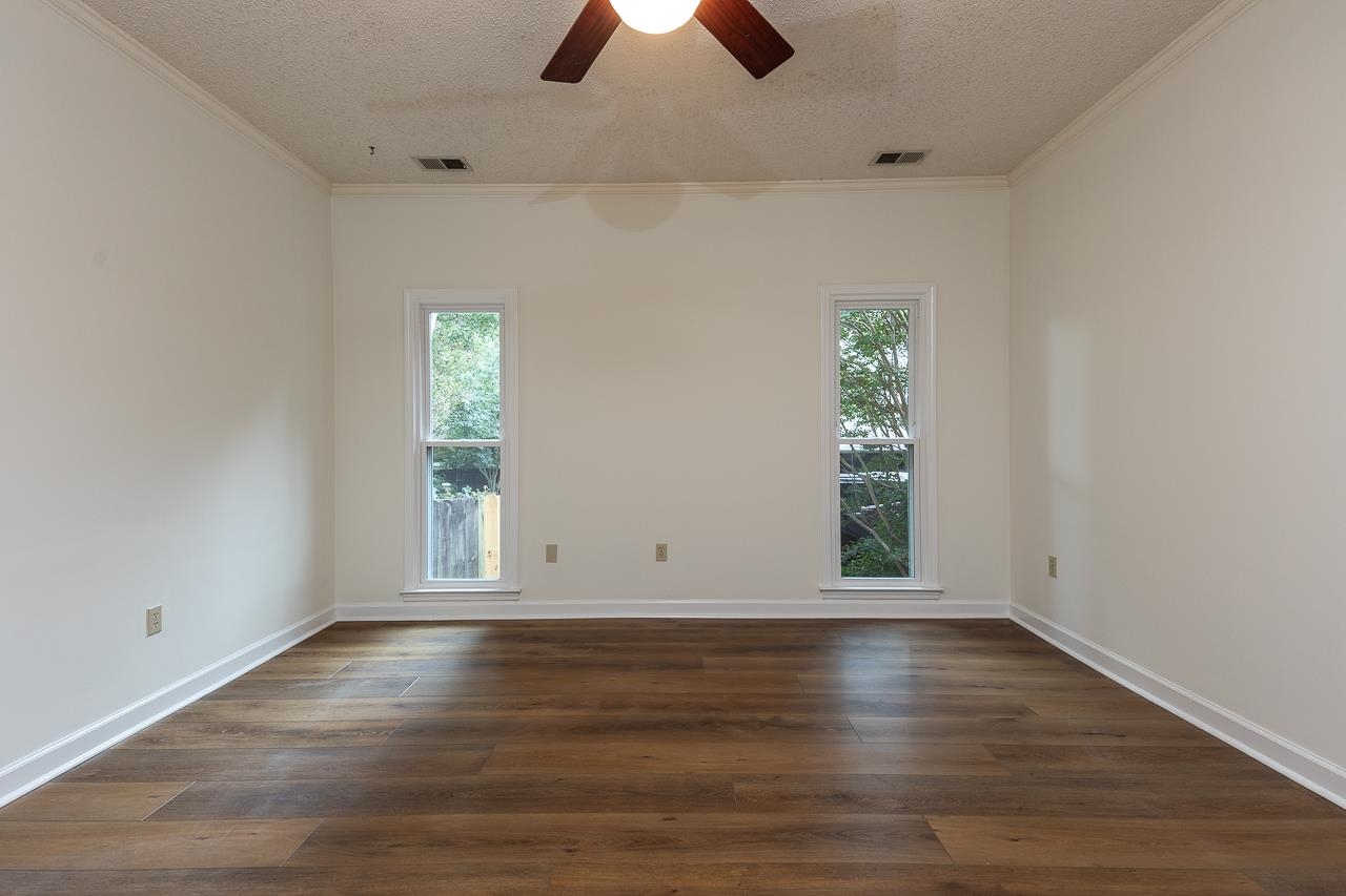 759 West Powell Road Collierville, TN 38017 - Photo 18 of 39 an empty room with wooden floor chandelier fan and windows