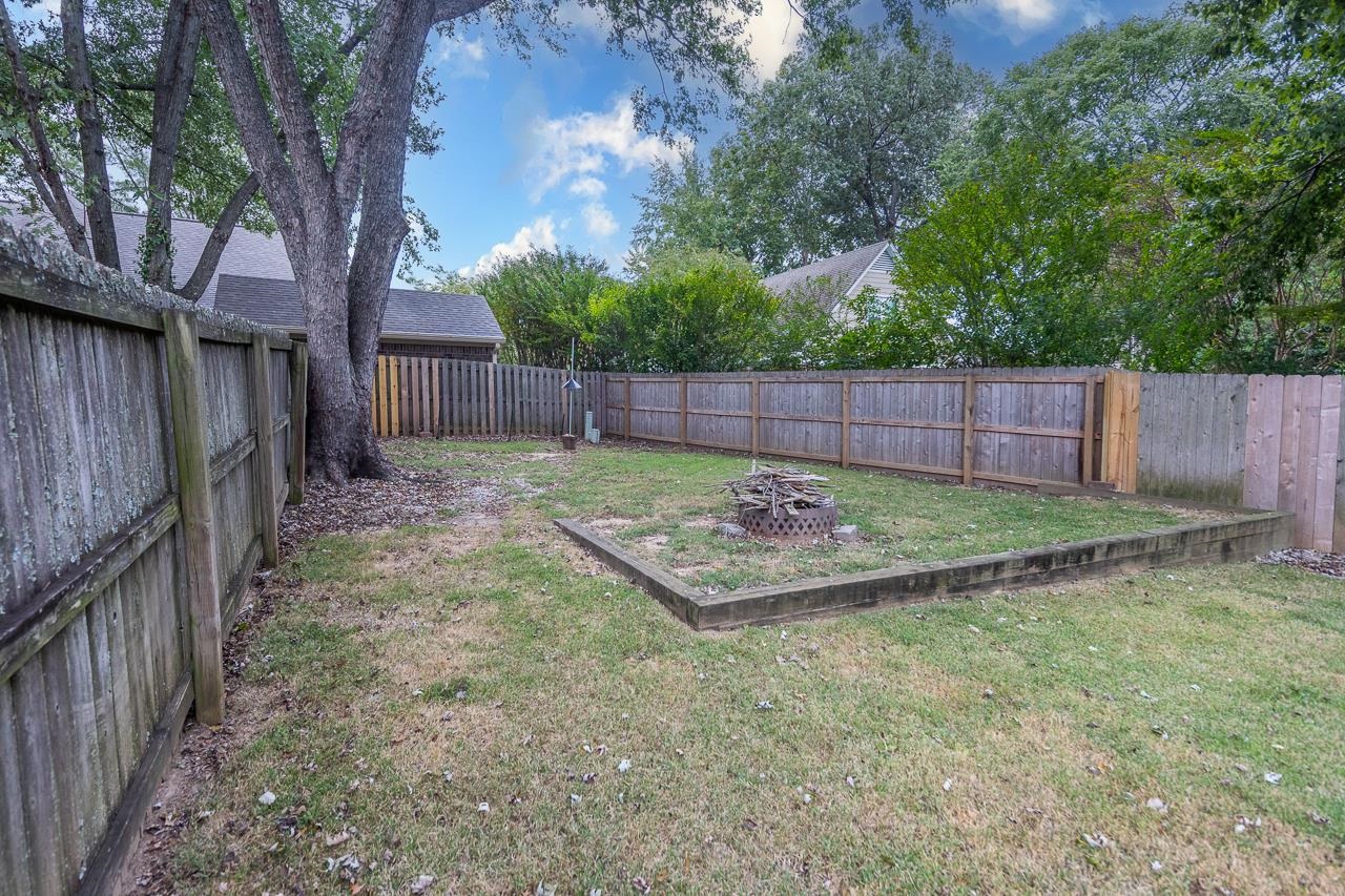 759 West Powell Road Collierville, TN 38017 - Photo 33 of 39 a view of a backyard with a large tree and wooden fence