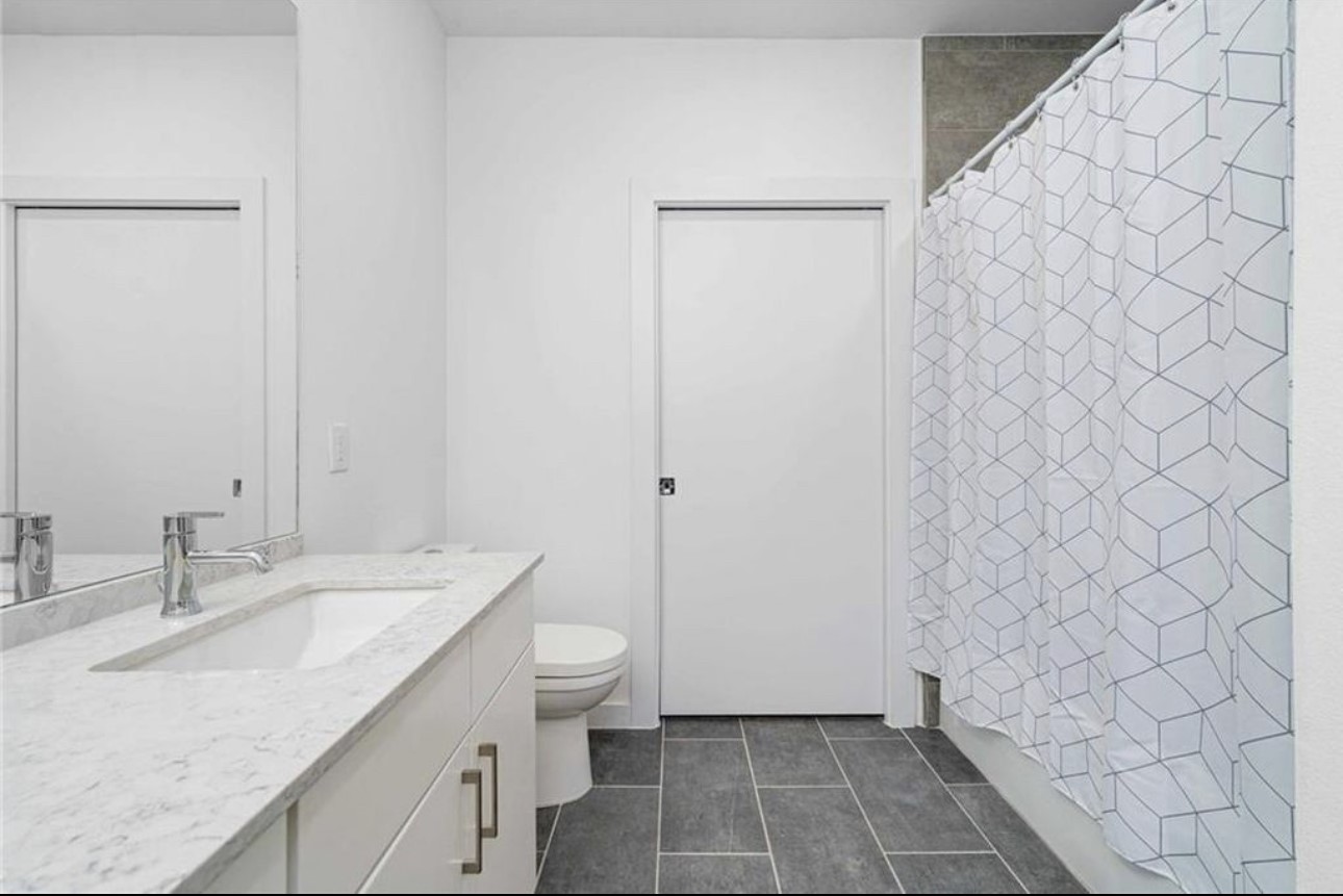 900 South 1st Street, Unit 304 Austin, TX 78704 - Photo 15 of 22 a bathroom with a granite countertop sink and a mirror