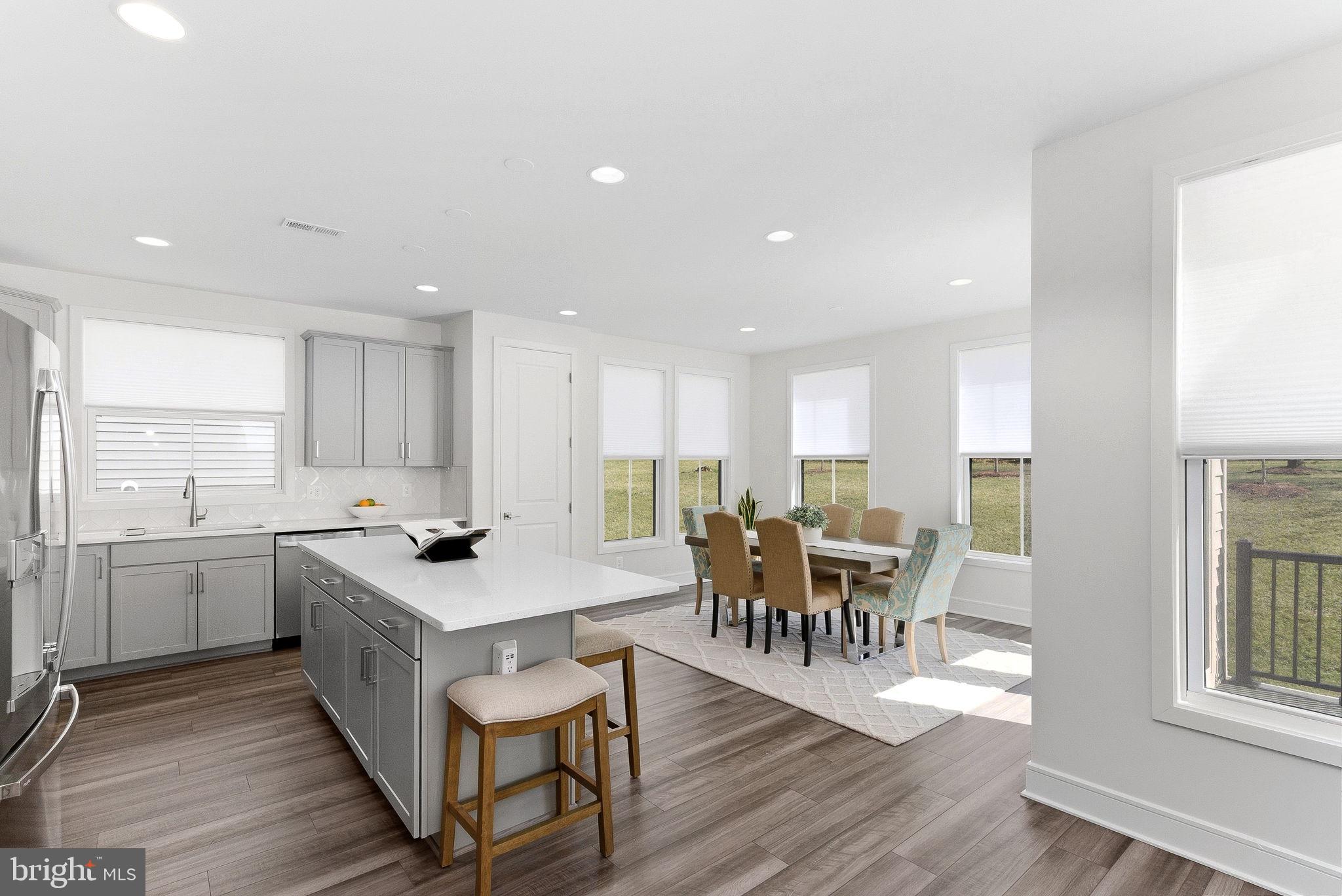 21340 Rainier Lane Broadlands, VA 20148 - Photo 12 of 62 a kitchen with a dining table chairs and wooden floor