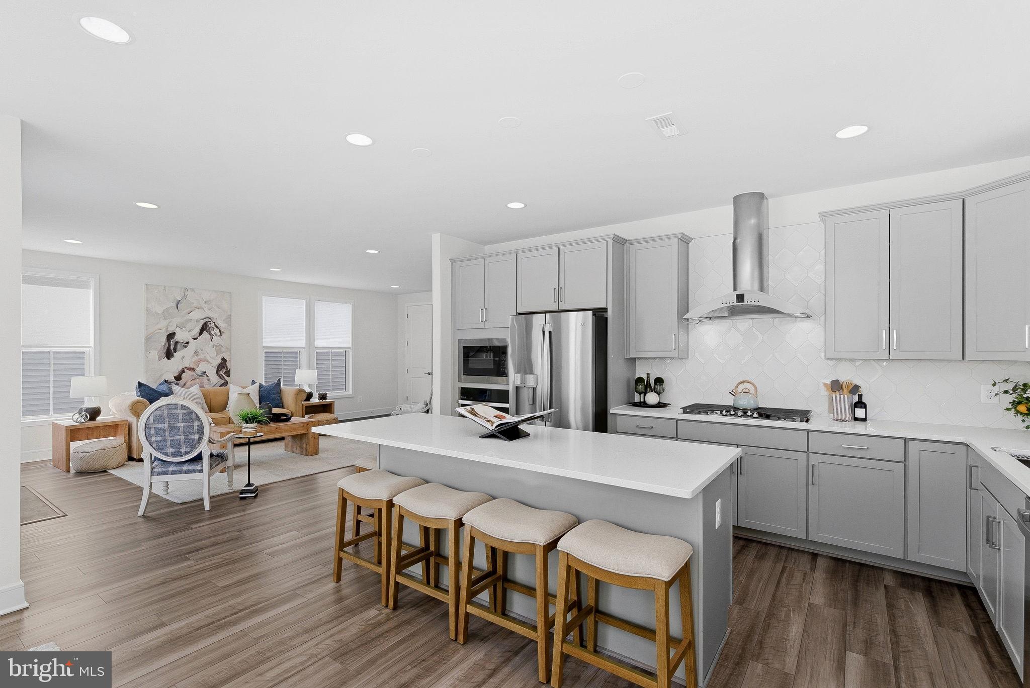 21340 Rainier Lane Broadlands, VA 20148 - Photo 18 of 62 a kitchen with stainless steel appliances a table and chairs in it