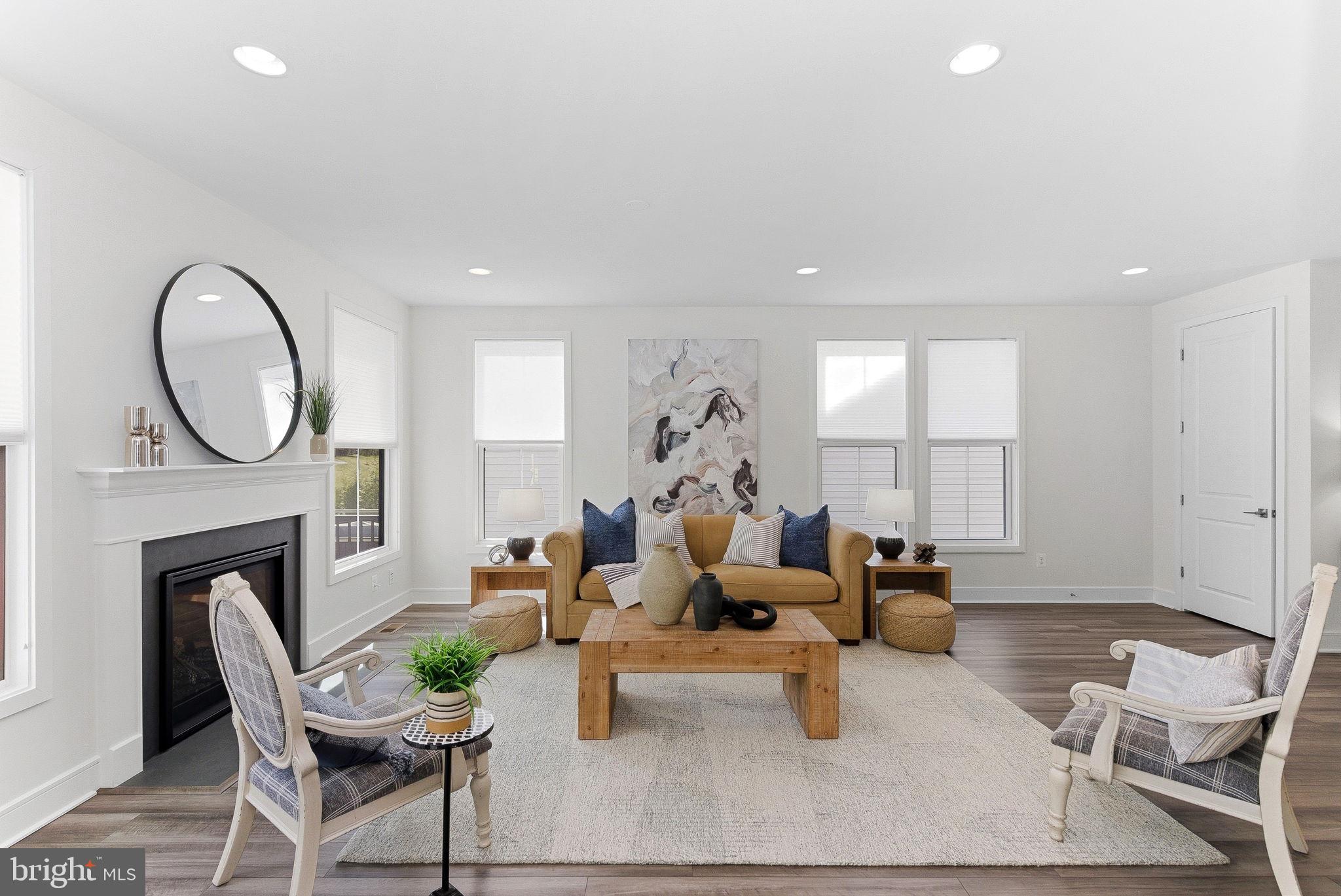 21340 Rainier Lane Broadlands, VA 20148 - Photo 6 of 62 a living room with furniture a fireplace a rug and a large window