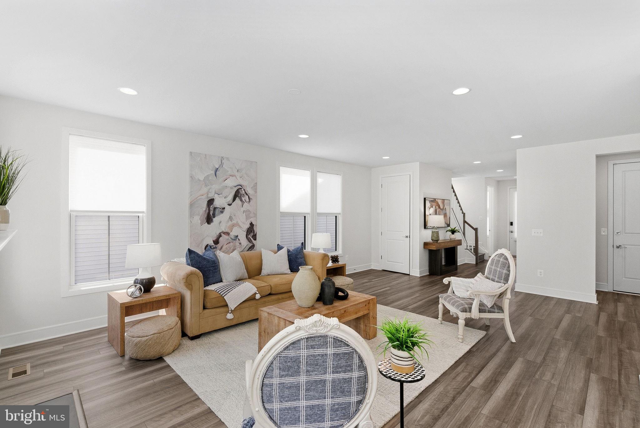 21340 Rainier Lane Broadlands, VA 20148 - Photo 7 of 62 a living room with furniture a wooden floor and a chandelier