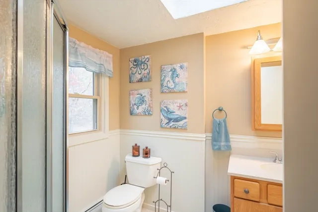 a bathroom with a granite countertop sink toilet and a mirror