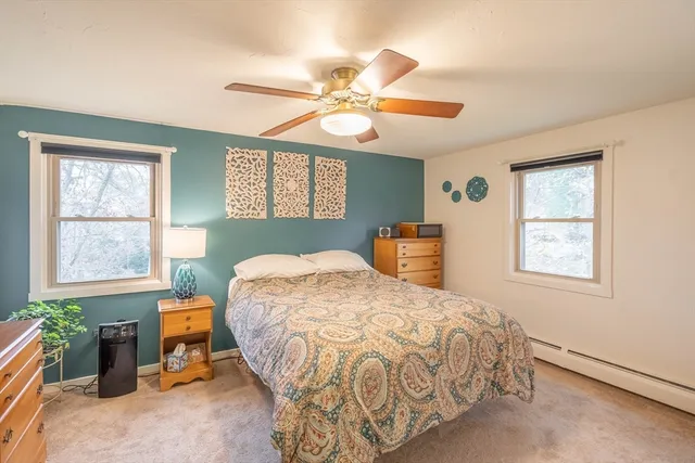 a bedroom with a large bed and a chandelier fan