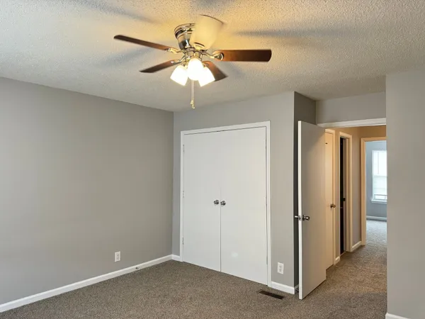 an empty room with a fan and a fan