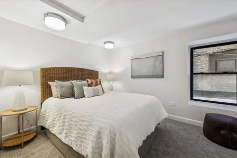 a bedroom with a bed and painting on the wall