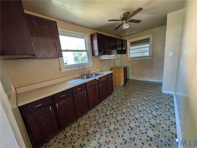 a kitchen with a sink a stove cabinets and a window