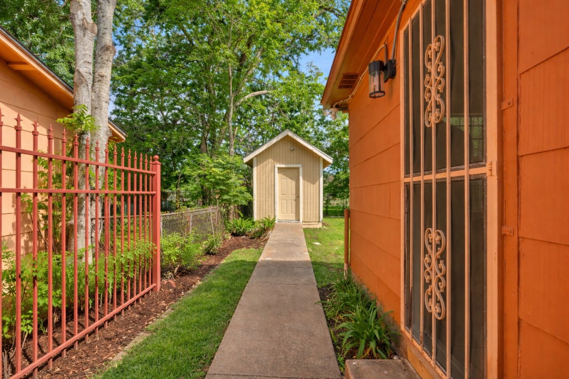 3922 Simsbrook Drive Houston, TX 77045 - Photo 23 of 32 Wide gate opens to a concrete sidewalk leading the the home's side entrance and also the Storage Shed.