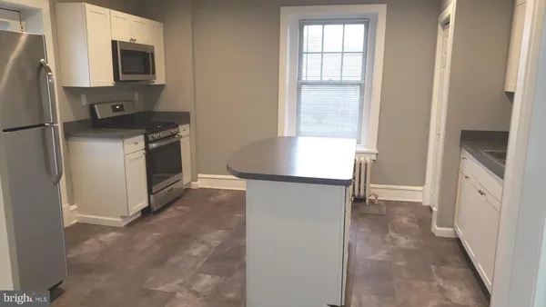 a kitchen with a refrigerator and a stove top oven