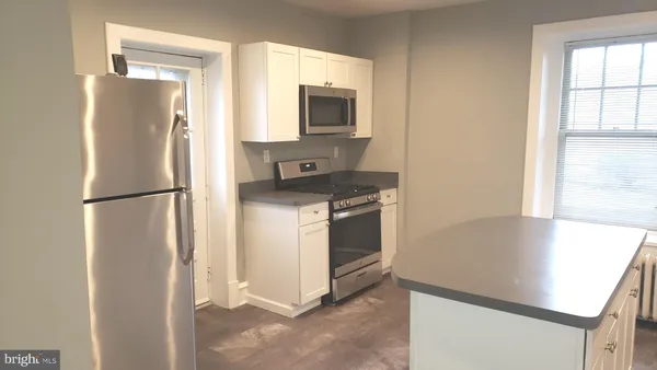 a kitchen with a refrigerator sink stove and cabinets