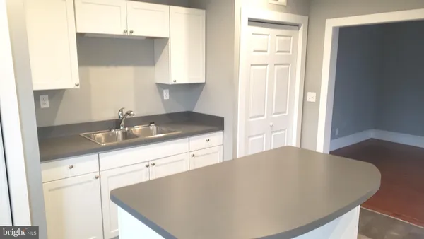 a kitchen with granite countertop a sink a stove and cabinets