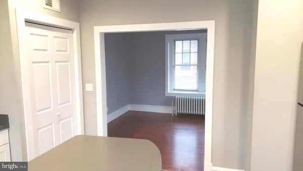 a view of a bedroom with wooden floor and windows