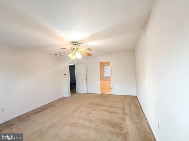 a view of a big room with windows and chandelier fan