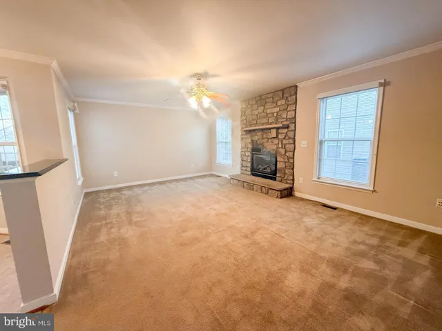 an empty room with windows and fireplace