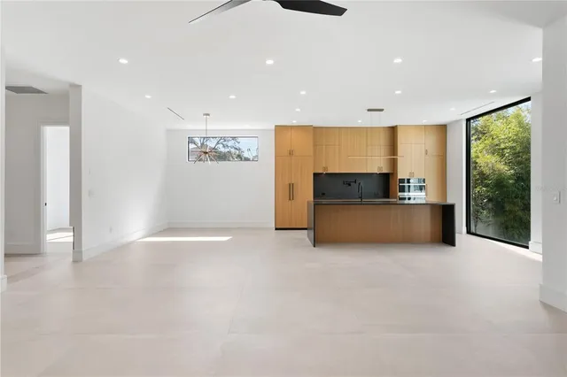 a view of kitchen with granite countertop white cabinets and a window