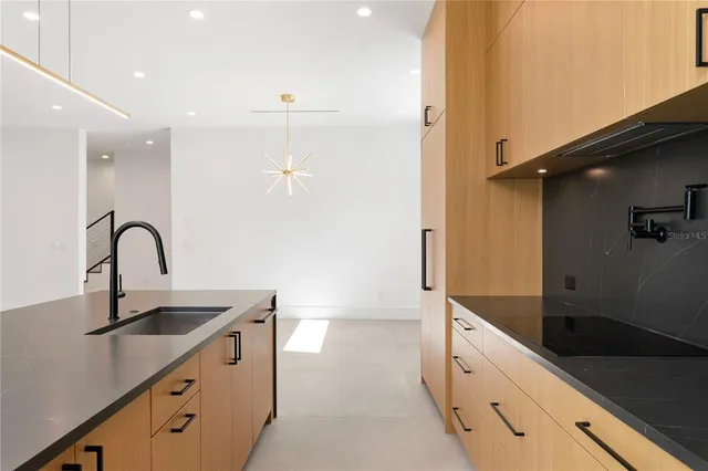 a view of an empty room with wooden floor and windows