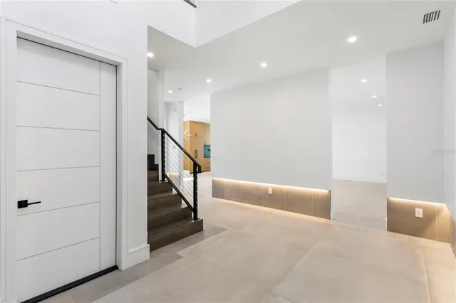 an empty room with ceiling fan and windows