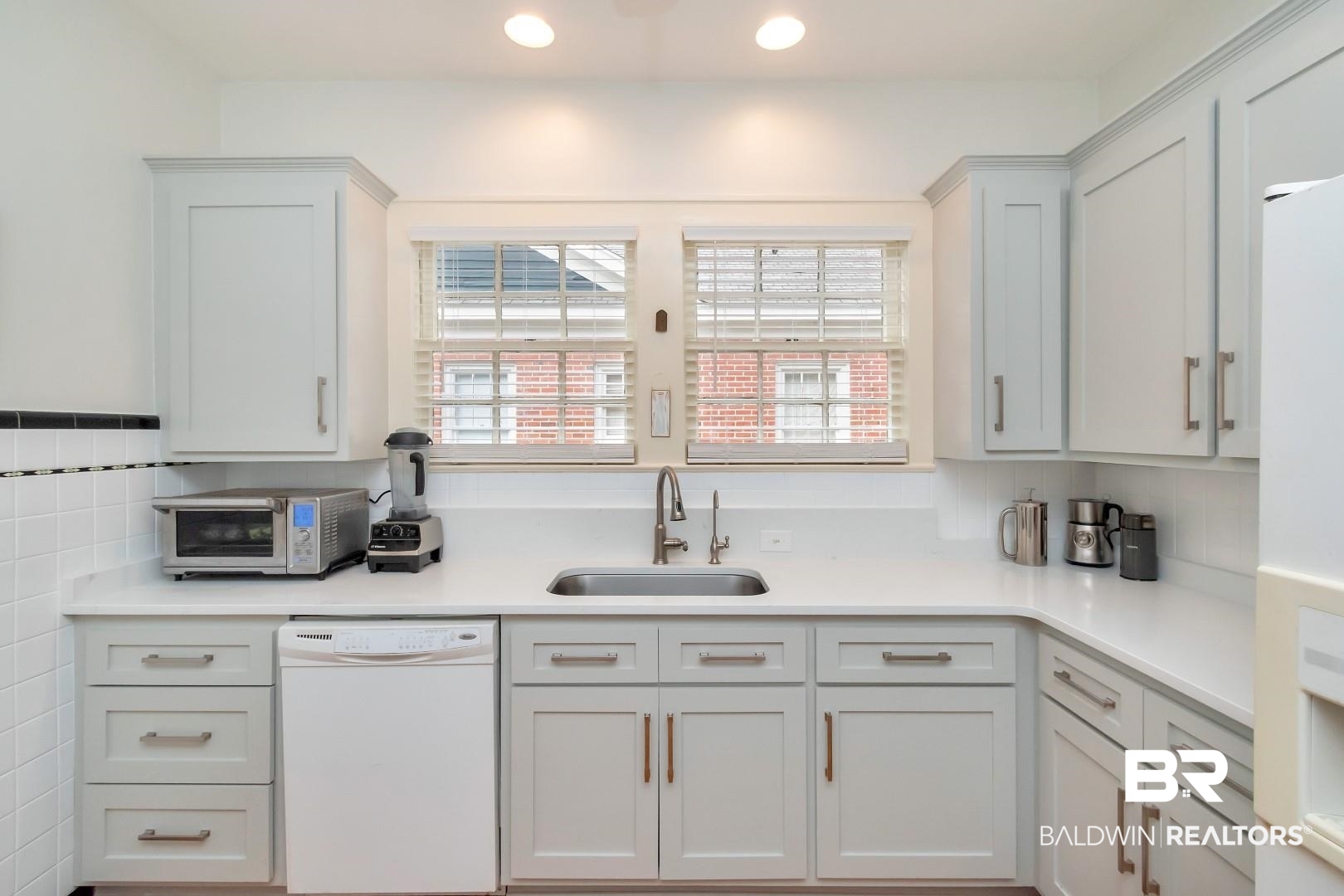 128 Silverwood Street Mobile, AL 36607 - Photo 11 of 34 Kitchen featuring white cabinets, backsplash, white dishwasher, and sink