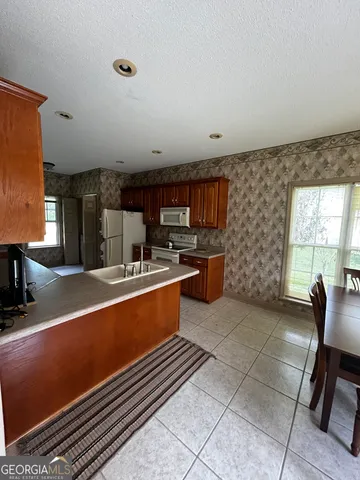 a kitchen with stainless steel appliances a sink a stove a microwave a counter top space and cabinets