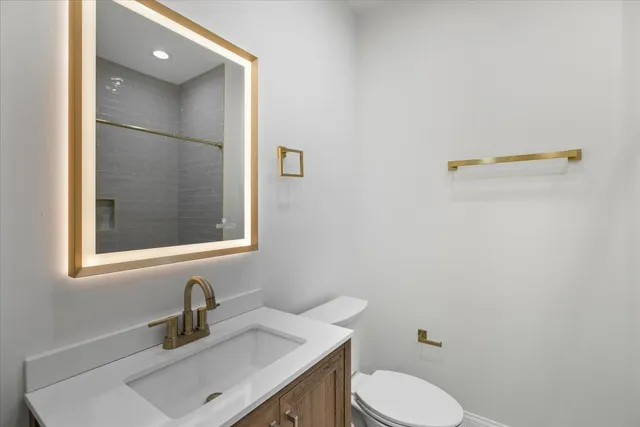 a bathroom with a sink vanity and toilet