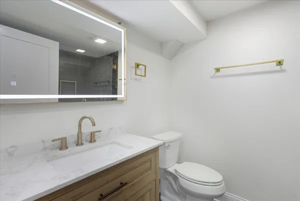 a bathroom with a sink a toilet and mirror