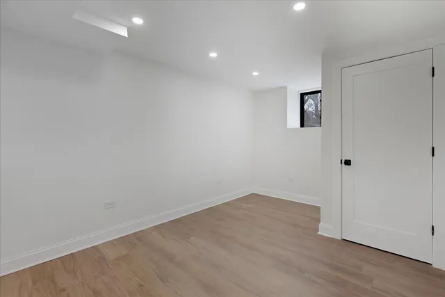 an empty room with wooden floor and window
