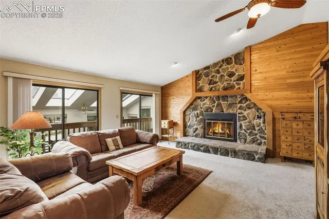 a living room with furniture a fireplace and a floor to ceiling window