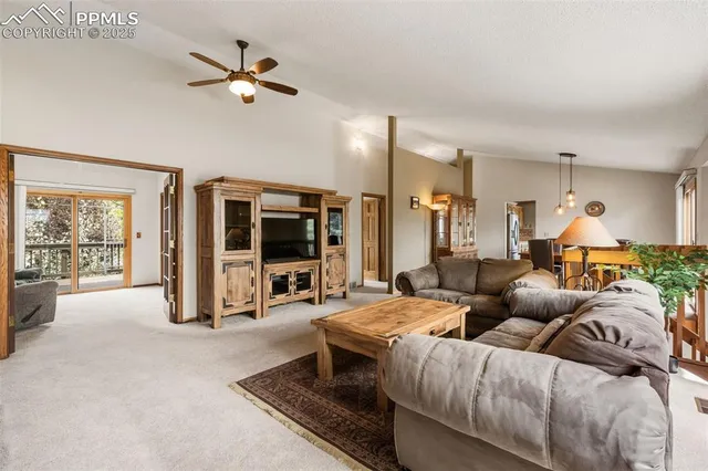 a living room with furniture ceiling fan and a large window