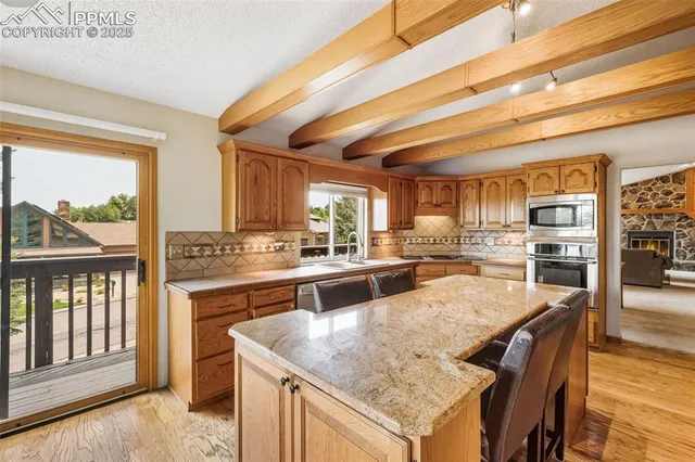 a large kitchen with granite countertop lots of counter space and stainless steel appliances