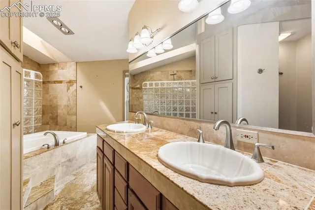 a bathroom with a granite countertop sink a large mirror and a bathtub