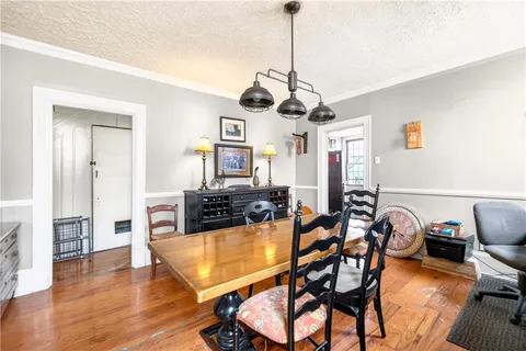 a view of a dining room and livingroom with furniture wooden floor a chandelier