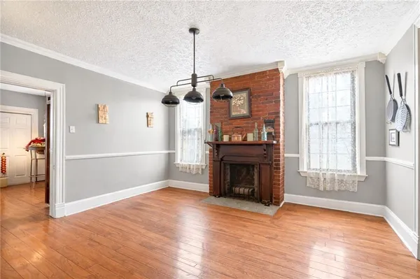 a view of empty room with wooden floor fireplace and windows