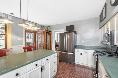 a kitchen with stainless steel appliances granite countertop a refrigerator a sink and a stove
