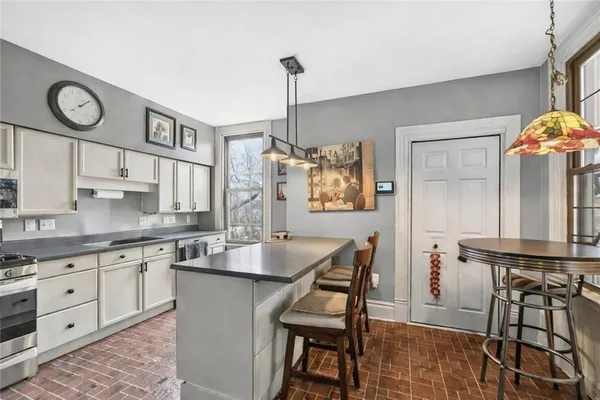 a very nice looking kitchen with granite countertop a stove two sinks and a chandelier