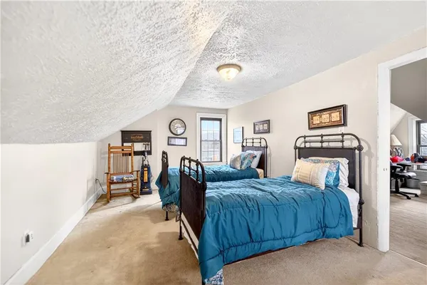 a bedroom with a bed and a view of kitchen