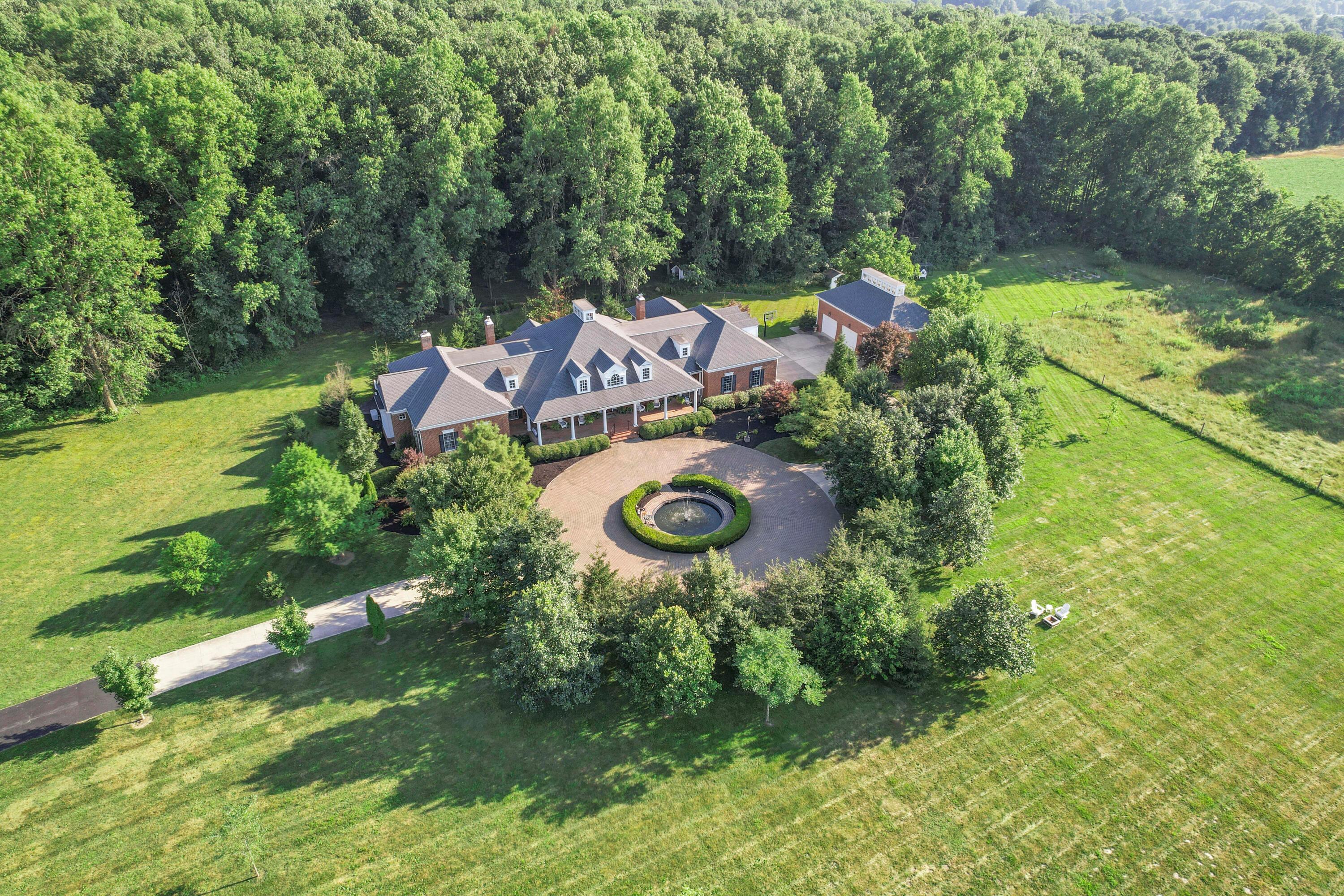 3575 State Rte 37 West Delaware, OH 43015 - Photo 3 of 106 Sprawling property featuring a brick residence with a prominent gabled roofline, a circular drive, and a central water feature